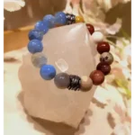Handmade blue agate and mookaite gemstone bracelet with 12 mm natural stones displayed on a crystal stone background.