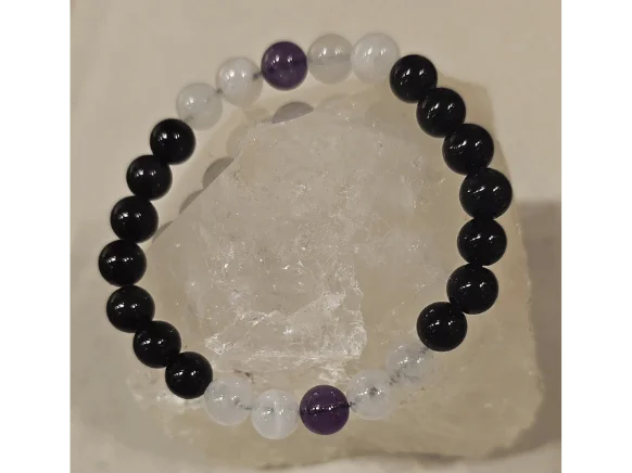 Handmade 8mm Amethyst, Rose Quartz, and Obsidian gemstone bracelet displayed on a clear quartz crystal, symbolizing protection, love, peace, and evil eye protection.