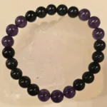 Handcrafted Obsidian and Amethyst gemstone bracelet featuring polished 8mm black and purple beads, symbolizing protection from the evil eye, grounding energy, wisdom, and inner peace.