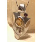 Handcrafted sterling silver pendant featuring a large golden citrine gemstone and vibrant rubellite accents in a modern geometric design, measuring 62 x 42 mm.