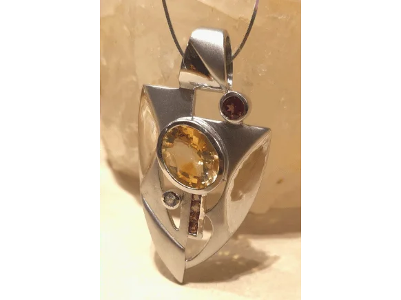 Handcrafted sterling silver pendant featuring a large golden citrine gemstone and vibrant rubellite accents in a modern geometric design, measuring 62 x 42 mm.