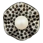 Handcrafted black silver ring featuring a natural white pearl surrounded by sparkling black spinel gemstones.