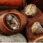 Handcrafted sterling silver lodolite pendants and black silver lodolite ring with natural Garden Quartz gemstones displayed on rustic stones.