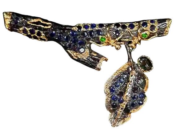 Handcrafted black silver brooch pendant with gold plating, natural sapphire, and tsavorite gemstones in an elegant convertible design.