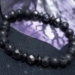 Handcrafted volcanic lava stone and hematite bracelet with natural 8mm black gemstone beads displayed on a dark background.